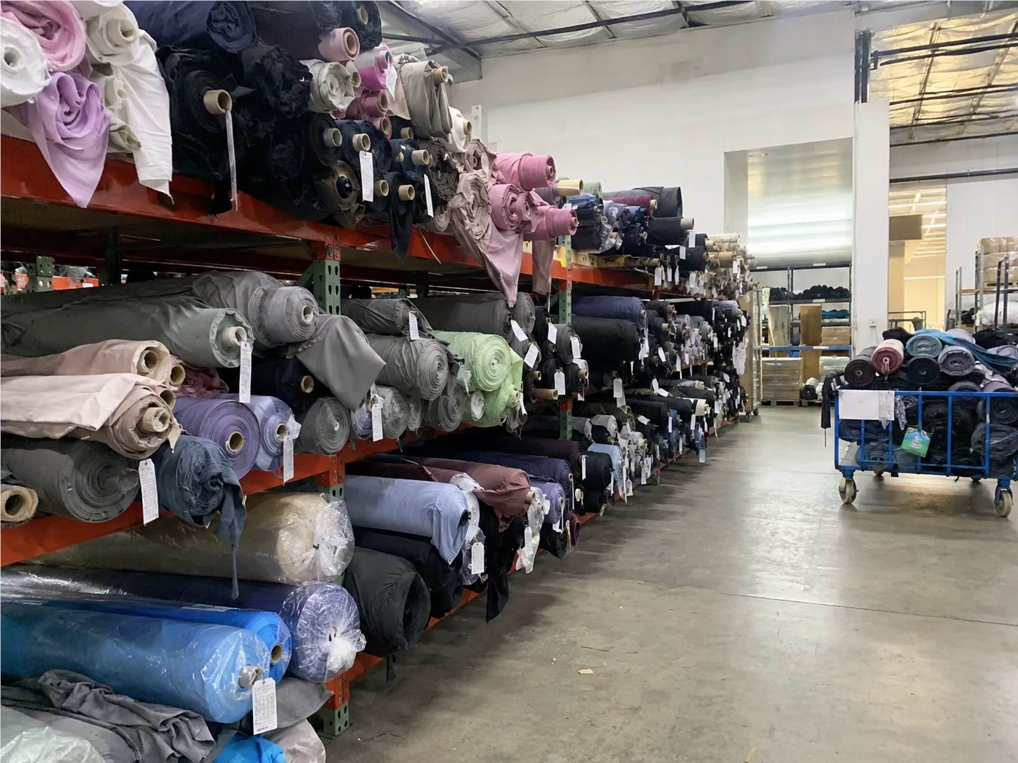 Stellarisle fabric warehouse with organized activewear material rolls for custom production